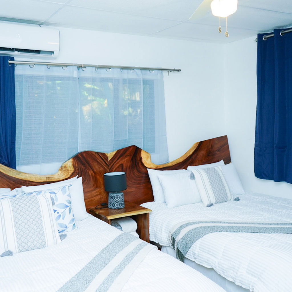 Cómodas habitaciones con mobiliario de madera, ideal para alojarse en Olas Permanentes.