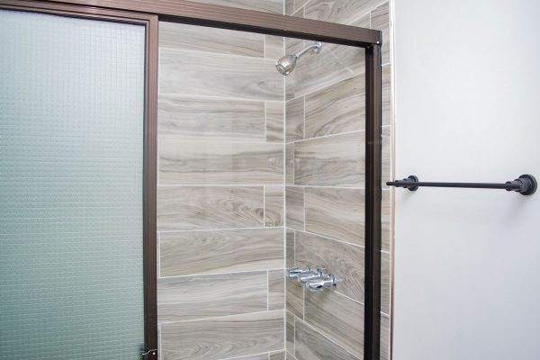 Novedoso baño con ducha de obra en cerámica porcelánica moderna y elegante.