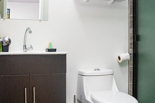 Baño moderno con lavabo y inodoro en vivienda de Olas Permanentes en surf.