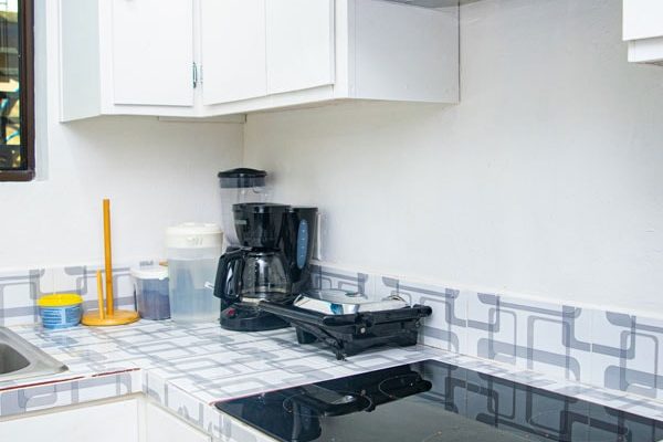 Cocina moderna con electrodomésticos blancos y encimera eléctrica.