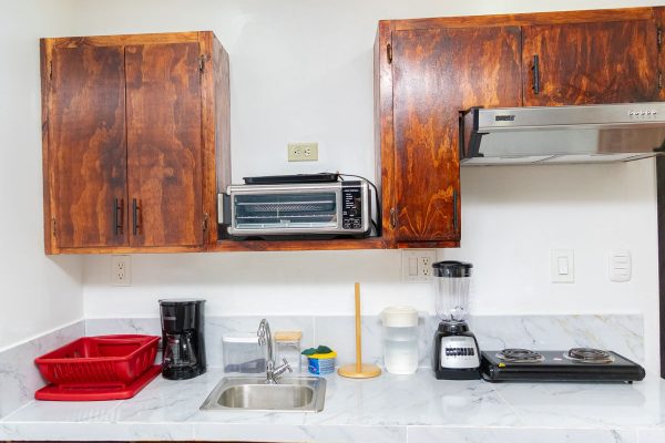Electrodomésticos de cocina en cocina con armarios de madera y encimera de mármol.