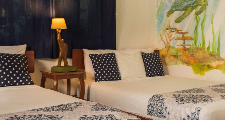 Habitación de hotel con arte tropical y camas cómodas en Olas Permanentes.