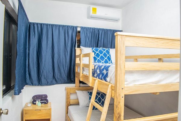 Cómoda habitación en alojamiento de surf con literas y decoración moderna.