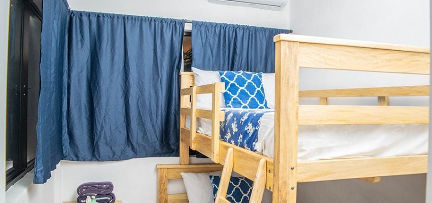 Cómoda habitación en alojamiento de surf con literas y decoración moderna.