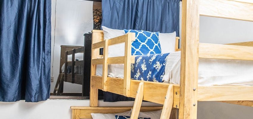 Buhardilla con literas de madera y literas trío en habitación familiar.