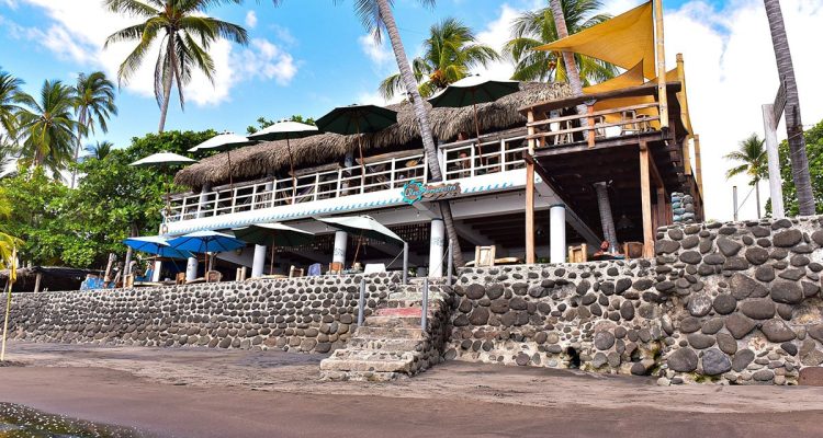 Olas Permanentes, restaurante frente al mar con terraza bajo palapa en zona de surf en Puerto Escondido.