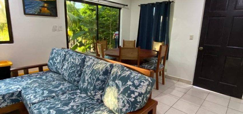 Sofá de madera con tapizado floral en interior de casa en Tulum.