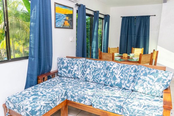 Cómodo sofá con funda de estilo tropical en sala de casa de vacaciones.