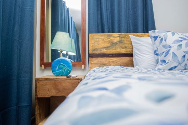 Un habitación acogedora con cama y decoraciones en tonos azules y madera natural.