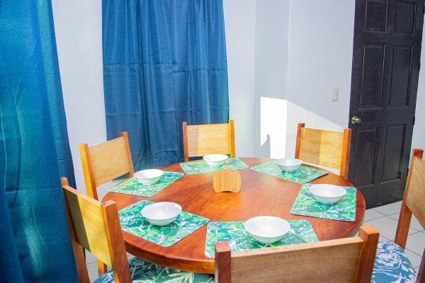 Mesa de comedor en interior decorada con temática de olas y naturaleza, ideal para un ambiente de restaurantes o cafeterías con estilo surfero.