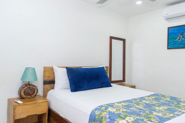 Cama doble en habitación de estilo sencillo en Olas Permanentes, ambiente relajante y decorado en tonos naturales.