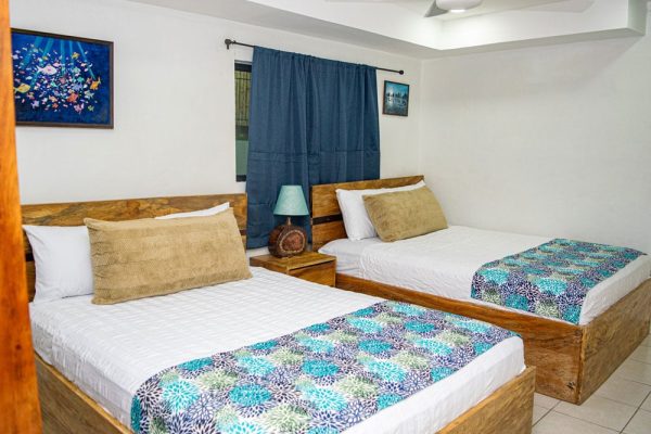 Conjunto de dos camas en habitación con decoración acogedora y estilo natural.