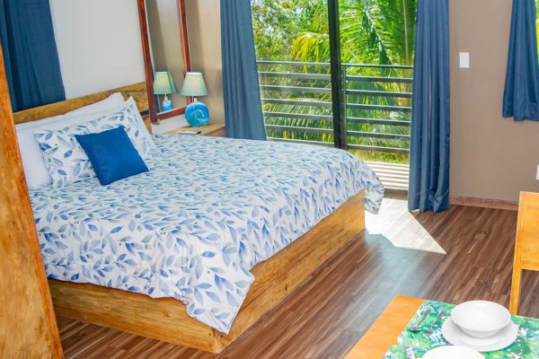 Linda habitación con balcón que ofrece vistas a la naturaleza en Olas Permanentes.