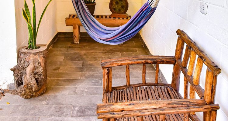 Madera rústica y plantas en ambiente natural para relajación en terraza de estilo surf.