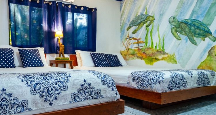 Cama doble con decoración tropical en habitación de Olas Permanentes.